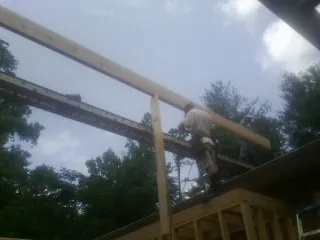 Carpenter setting a ridge beam over a new addition frame — Ice Dam Removal by Roofing Brothers in Ghent
