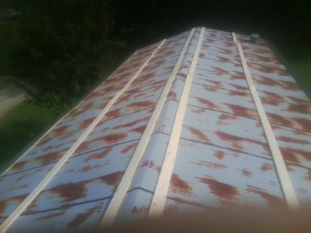 Rusted metal roof panels with new wood purlins before replacement — Storm Damage Roof Repair in Ghent by Roofing Brothers