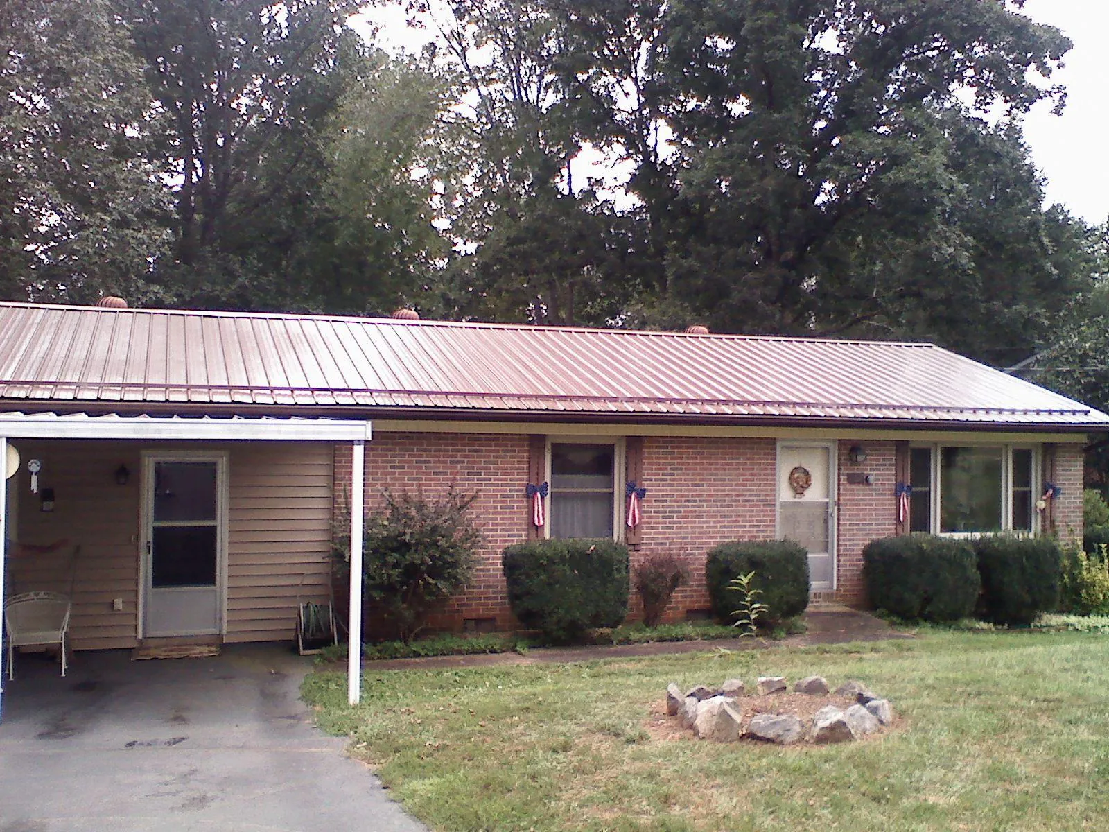 Bronze metal roof and carport on a brick ranch home — Roof Repair work by our crew in Ghent